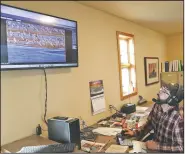  ??  ?? Josh Wiese, habitat ecologist with the Crane Trust, views the camera they have set up for the online tour they offer to birdlovers.