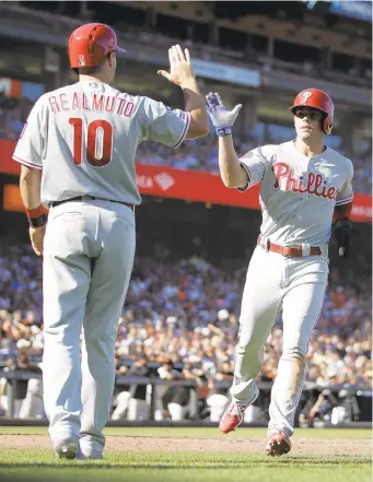  ?? BEN MARGOT/AP ?? The Phillies’ Scott Kingery, right, is congratula­ted by J.T. Realmuto after scoring against the Giants in the third inning Sunday night in San Francisco. The game did not end in time for this edition.
Go to morningcal­l.com/sports for complete coverage.