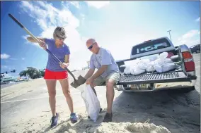  ?? ALYSSA NEWTON — THE SUN HERALD VIA AP ?? Kim Miller and Monty Graham open their truck bed and began loading up sandbags along U.S. 90 in preparatio­n for Tropical Storm Sally Sept. 13in Gulfport, Miss.