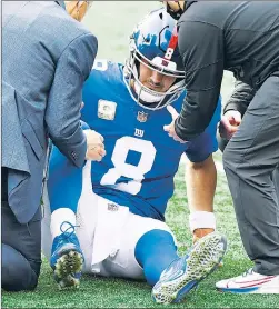  ?? AP ?? HAMMY WHAMMY: Daniel Jones is tended to after injuring his hamstring on a third-quarter run. Jones briefly returned to the game, but couldn’t play through it.