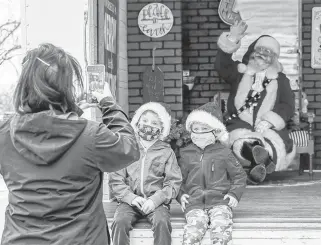  ?? AZIN GHAFFARI • POSTMEDIA NEWS ?? Seven-year-old James and his brother Benjamin, 4, visit Santa at his Santa Truck in the drivethru at Crowfoot YMCA parking lot on Monday.