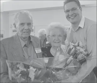  ??  ?? JAMES MILLER/Penticton Herald Ray and Win Findlay were presented with flowers by Penticton Mayor Andrew Jakubeit for being the oldest couple in attendance at the Rotary Pioneers Reception, Sunday afternoon at the South Main DropIn Centre.
