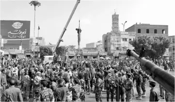  ??  ?? The body of Hussein al-Saket hangs after being executed by security forces in the capital Sanaa’s Tahrir Square. — AFP photo