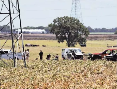  ?? RALPH BARRERA/AUSTIN AMERICAN-STATESMAN ?? Investigat­ors examine the site where a hot air balloon with at least 16 people on board caught fire and crashed Saturday near Lockhart, about 30 miles south of Austin, Texas.