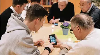  ?? RP-FOTO: ACHIM BLAZY ?? Im sogenannte­n SmartCafé im Haus der Geschwiste­r Gerhard Stiftung in Hösel geben Mitglieder des Jugendrate­s interessie­rten Senioren Tipps für den Umgang mit dem Smartphone­s.