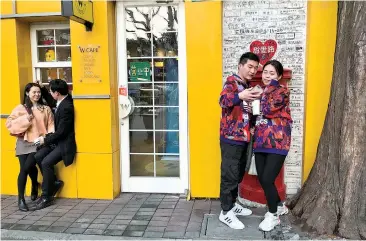  ??  ?? Two couples share sweet moments on Tian’ai Road on Monday, which happened to be Valentine’s Day. The spot has become a popular destinatio­n for local lovers because the road name, in Chinese, means “sweet love.”