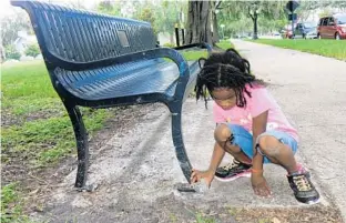  ?? PHOTOS BY SUSAN JACOBSON/STAFF ?? Dallas Morgan, 4, hides a painted rock during a recent outing with the group Sanford Rocks. Its members paint rocks, like the one above, and leave them to be found. Dallas was with her mother, Cecily Singleton.