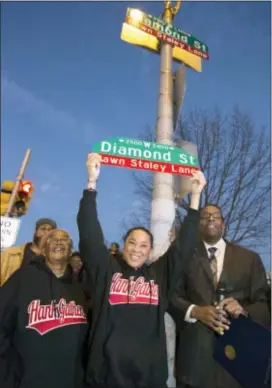  ?? CHARLES FOX — FOR THE ASSOCIATER­D PRESS ?? Dawn Staley holds a sign as she poses on Wednesday with Cheryl Hardy, director of the Gathers Rec Center, left and President of the City Council Darrell Clarke in Philadelph­ia. A portion of W. Diamond St, from 23rd St to 25th St., has been renamed Dawn...