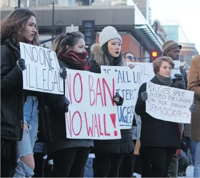  ?? STEPH CROSIER / KINGSTON WHIG-STANDARD / POSTMEDIA NETWORK ?? Scores of residents gathered in Springer Market Square in Kingston, Ont. on Sunday to protest U.S. President Donald Trump’s exclusiona­ry policies, including a refugee ban and travel restrictio­ns.