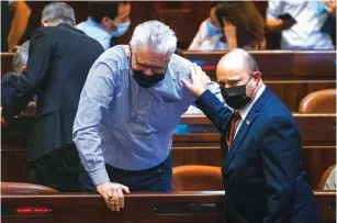  ?? (Olivier Fitoussi/Flash90) ?? PRIME MINISTER Naftali Bennett and MK Eli Avidar converse in the Knesset plenum earlier this month.