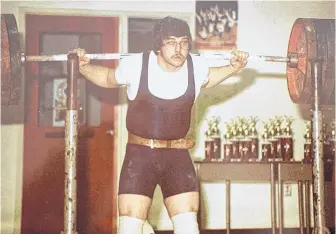  ?? CONTRIBUTE­D • GLEN HUTCHISON ?? Glen Hutchison competing in a powerlifti­ng event in the early years of his 45-year career in the sport. Hutchison still goes to the gym and remains active as he battles cancer.