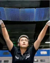  ?? (Photo by VCG) ?? A worker holds up photovolta­ic panels at Anhui Daheng Energy Technology Co Ltd, Hefei, Anhui Province, June 6, 2023