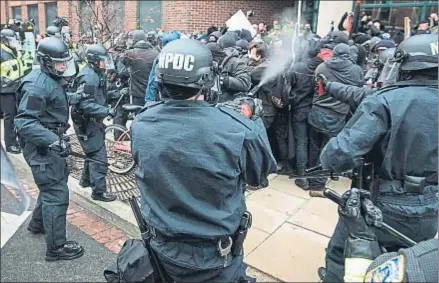  ?? ZACH GIBSON / AFP ?? Policías lanzando espráis en Washington contra manifestan­tes contrarios a Trump antes del juramento