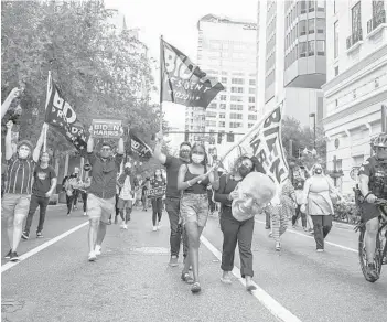  ?? WILLIE J. ALLEN JR./ORLANDO SENTINEL ?? President-elect Joe Biden supporters march down Orange Avenue on their way to Orlando City Hall on Saturday in Orlando. Democrat Biden defeated President Donald Trump to become the 46th president of the United States on Saturday, positionin­g himself to lead a nation gripped by a historic pandemic and a confluence of economic and social turmoil.