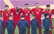  ?? ?? Iran players remain mute during the national anthem in Doha yesterday, while, below, protesters in the stadium made their feelings known