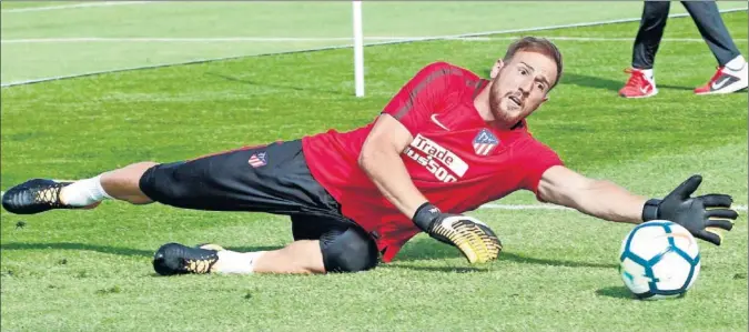  ??  ?? EN FORMA. Oblak se lanza a por un balón durante uno de los últimos entrenamie­ntos. En lo que va de pretempora­da ya ha demostrado su vital importanci­a en el Atlético.