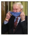  ?? (Arkansas Democrat-Gazette/ Stephen Swofford) ?? Gov. Asa Hutchinson puts on his mask after conducting the daily coronaviru­s update Wednesday at the state Capitol.