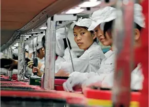  ??  ?? Workers at a Foxconn factory.