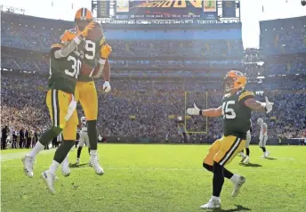  ?? WM. GLASHEEN / USA TODAY ?? Jamaal Williams (30) celebrates a touchdown in the second quarter with tight end Marcedes Lewis (89) and fullback Danny Vitale.