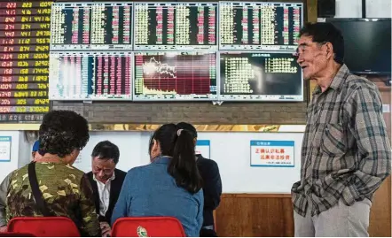  ??  ?? Market gain: Investors looks at an electronic board showing stock informatio­n at a brokerage house in Shanghai. The Shanghai Composite Index climbed 2.6% yesterday after sliding as much as 1.5% in the morning.