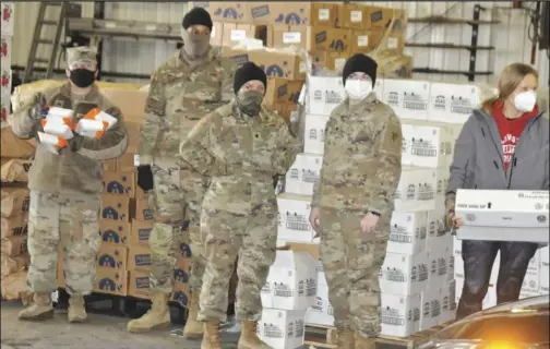  ??  ?? The Wast Ohio Food Bank was back in Wapakoneta Friday. Here, members of the Ohio National Guard, and volunteers from St. Paul United Church of Christ, who has partnered with the area food bank for months, were getting ready to deliver food to families in need. The distributi­on was held at the Auglaize County Engineer's Garage. A total of 32,500 pounds of food was distribute­d to 167 families.