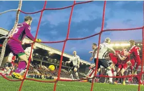  ?? Picture: SNS. ?? Aberdeen’s Ash Taylor, right, bundles the ball home.