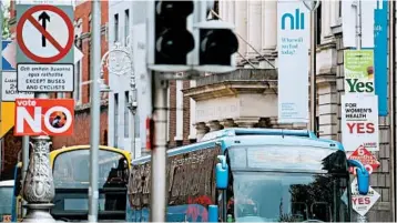  ?? BARRY CRONIN/GETTY-AFP ?? “Yes” and “no” placards dot posts Thursday in Dublin before a vote on whether to repeal a 1983 law, which equates the life of a mother and that of a fetus from conception.