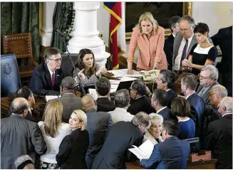  ?? DEBORAH CANNON / AMERICAN-STATESMAN ?? Lt. Gov. Dan Patrick and Senate Parliament­arian Karina Davis talk with senators Tuesday after Sen. Jose Rodriguez, D-El Paso, called a point of order during the first day of the Legislatur­e’s special session. The Senate will vote on two “sunset” bills...