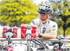  ??  ?? Above: Thomas Lamorte prepares his bike to take on the 116-mile ride during Ironman. All athletes began on the bike portion because the swim portion of the event was canceled because of recent flooding in the area.Left: Garland Sullivan leads the pack during Ironman on Sunday.