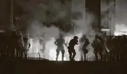  ??  ?? Protesters clash with riot police on the steps of the Serbian parliament during a protest in Belgrade, Serbia, on Friday. It was the fourth night of protests.