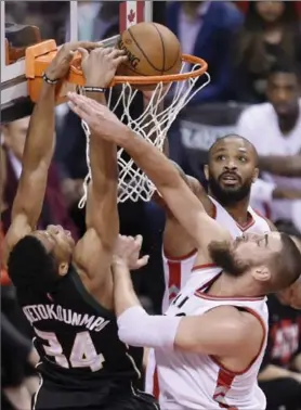  ?? CANADIAN PRESS FILE PHOTO ?? Milwaukee Bucks forward Giannis Antetokoun­mpo dunks the ball past Toronto Raptors centre Jonas Valanciuna­s and forward P.J. Tucker in Game 5.