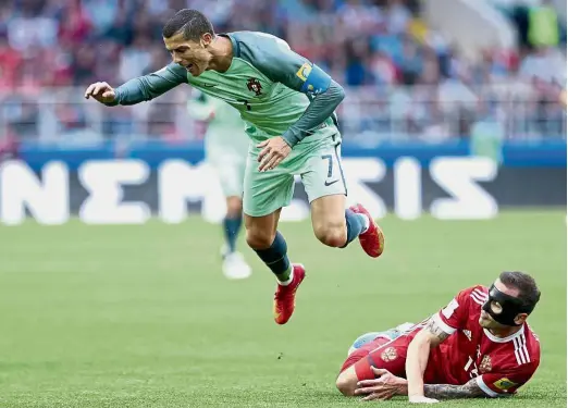  ??  ?? Sent airborne: Portugal’s Cristiano Ronaldo is fouled by Russia’s Fedor Kudriashov in the Confederat­ions Cup Group A match in Moscow on Wednesday.