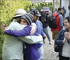  ?? ?? Carlos Munoz reaches out to hug Larkin Stallings of Vineyard Haven, as the immigrants prepare to leave Martha’s Vineyard on Friday.