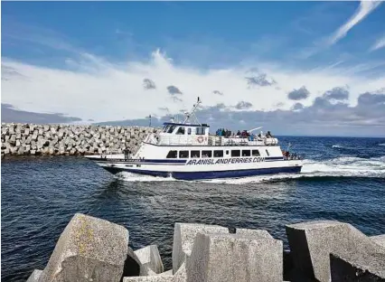  ?? Andy Haslam photos / New York Times ?? A ferry from the Irish mainland heads into Inishmaan harbor. The island of Inishmaan is less than 4 square miles. Its village consists of one shop and one bar.