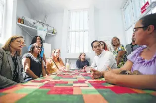  ?? Carlos Giusti / Associated Press ?? San Juan Mayor Carmen Yulín Cruz, left, and presidenti­al hopeful Julián Castro meet with residents in Playita. Residents said they still need help more than a year after Hurricane Maria