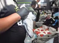  ?? ?? Snkrr Bar employees clean and repair a variety of shoes at the sneaker cleaning storefront in Midtown.