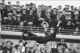  ?? MATT SLOCUM, THE ASSOCIATED PRESS ?? A Navy Midshipman is tossed in the air as fans celebrate a touchdown against Army.