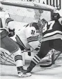  ?? GENE J. PUSKAR/AP ?? The Penguins’ Sidney Crosby, right, pokes the puck under the pad of Rangers goaltender Igor Shesterkin, middle, during the first period in Game 4 Monday in Pittsburgh.