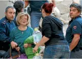  ??  ?? A woman cries after been rescued from her home following a quake in Amatrice.