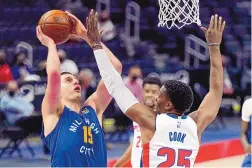  ?? CARLOS OSORIO/ASSOCIATED PRESS ?? Denver’s Nikola Jokic puts up a shot against Detroit’s Tyler Cook during Friday’s game in Detroit. Jokic had a triple-double as the Nuggets downed the Pistons, 104-91.