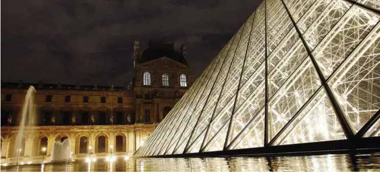  ??  ?? MODEL OF EFFICIENCY: The Louvre all lit up at night with the warm glow of LED lighting. IBM is working with the famed museum to make the building more efficient. — AP