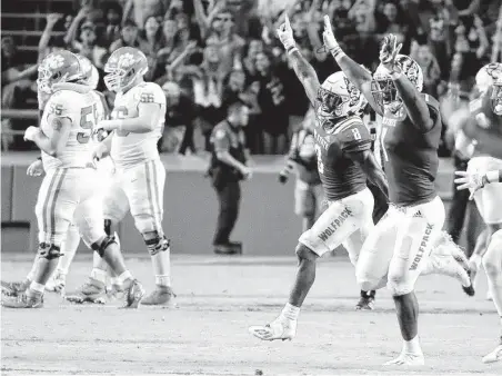  ?? Karl B DeBlaker / Associated Press ?? North Carolina State players celebrate their double-overtime victory over No. 9 Clemson on Saturday in Raleigh, N.C.