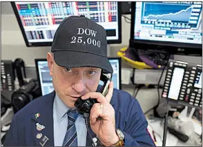  ?? AP/MARK LENNIHAN ?? Vincent Pepe, a commoditie­s broker with ICAP Corp., wears a commemorat­ive hat while working at the New York Stock Exchange on the Dow’s record-setting day.