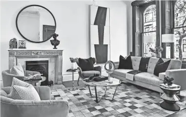  ?? HANDOUT ?? Sharp accents of black including artwork, toss pillows and throw add a sense of luxury in this living space.