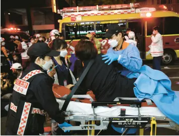  ?? CHUNG SUNG-JUN/GETTY ?? Emergency workers remove injured victims after a stampede left scores of people dead or hurt Saturday night in a nightlife district in Seoul, South Korea.