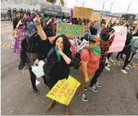  ??  ?? Protesters gather and carry signs during the demonstrat­ion against violence toward women in Mexico.