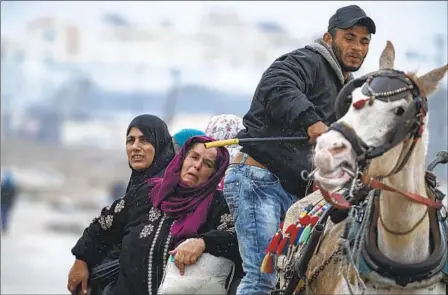  ?? FATIMA SHBAIR AP ?? Palestinia­ns arrive in the southern Gaza town of Rafah on Monday after fleeing an Israeli ground and air offensive in the nearby city of Khan Younis. Discussion­s on a potential six-week pause in the war between Israel and Hamas are in the early stages.