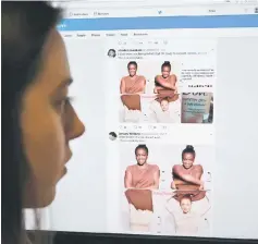  ??  ?? A posed picture taken in London shows a journalist looking at screenshot­s retweeted by Twitter users on the social networking site of a video-clip used in an online advert by the personal care brand Dove that originally appeared on social networking...