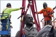  ?? AP PHOTO/STEVE HELBER ?? Crews work to remove one of the country’s largest remaining monuments to the Confederac­y, a towering statue of Confederat­e General Robert E. Lee on Monument Avenue, Wednesday, Sept. 8, 2021, in Richmond, Va.