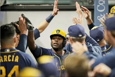  ?? TONY DEJAK — THE ASSOCIATED PRESS ?? The Brewers’ Lorenzo Cain celebrates with teammates after Cain hit a grand slam in the fifth inning.